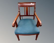An antique mahogany scroll armchair.