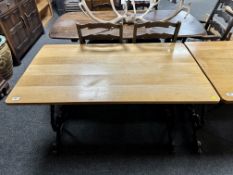 An oak topped rectangular bar table on cast iron legs.