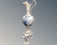 A ceramic blue and white oversized jug on stand (a/f) together with a further ceramic water pump.