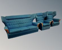 A mid-20th century three piece G-Plan wingback lounge suite upholstered in a green fabric.