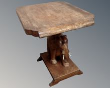 A carved hardwood occasional table on elephant support.