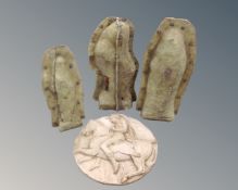 A circular plaster relief plaque together with three concrete statue moulds containing statues.