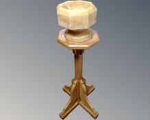 A 20th century ecclesiastical oak stand with marble font.