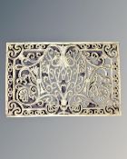 A rectangular cast iron doormat.