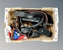 A box containing tooled leather gun belts, holsters and bandoliers together with a flag.