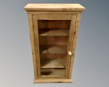 A stripped pine glazed door low cabinet.