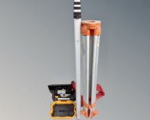 A precision surveyor's theodolite on stand together with a five meter measure