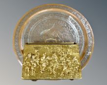 An Indian circular copper embossed plaque and a brass magazine rack