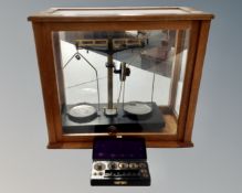 A set of vintage chemist's balance scales in case and a Bakelite cased set of weights