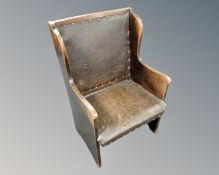 An Edwardian oak high backed lambing chair