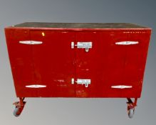 A painted double door workshop cabinet on castors