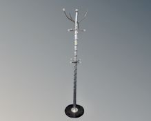 A contemporary hat and coat stand on circular base.