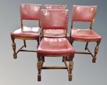 A set of four oak dining chairs upholstered in a red button leather.