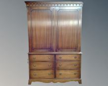 A Reprodux Georgian style linen press fitted with six drawers beneath.