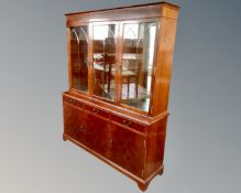 A good quality inlaid yew wood triple door bookcase fitted with cupboards and drawers beneath.
