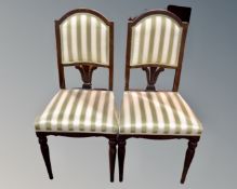 A pair of occasional chairs on reeded legs, upholstered in a green and cream striped fabric.