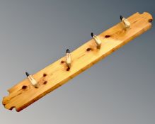 A rustic pine and taxidermy coat rack with five deers hoof hooks.