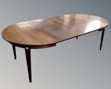 A 20th century Danish circular extending dining table in a rosewood finish with two leaves.