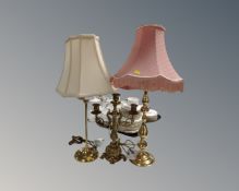 A gilt metal three way table candelabrum together with two brass table lamps, with shades.