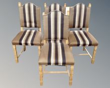 A set of four 20th century blond oak dining chairs upholstered in a striped fabric.