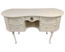 A cream and gilt kidney shape dressing table.