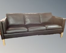 A Scandinavian three seater settee with black leather cushions.