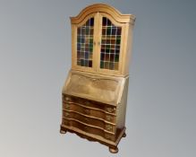 A 20th century Scandinavian oak secretaire bureau fitted with four drawers beneath and leaded glass