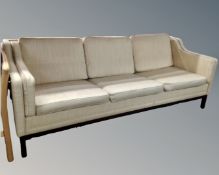 A 20th century Scandinavian three seater settee with beige fabric cushions.
