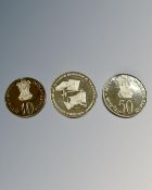 A silver (.500) 50 Rupee coin together with silver (.