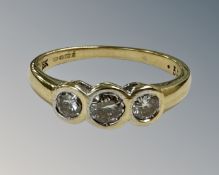 An 18ct gold three stone diamond set ring, the stated total diamond weight 0.50 carat, size N.