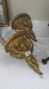 A pair of gilded plaster cherub wall brackets.
