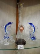 Two glass dolphins, a cut glass vase and a glass hot air balloon under dome.