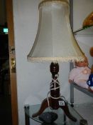 A three legged oak table lamp.
