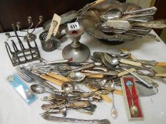 A mixed lot of flat ware, toast rack, candlesticks etc.,