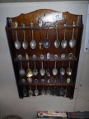 A selection of tourist collectors spoons on rack