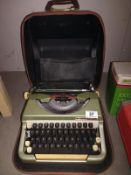 A cased vintage typewriter, name badge indistinct