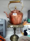 An old early 20th century copper kettle on stand