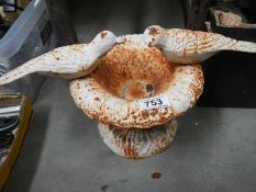 An old cast iron bird bath with 2 cast birds