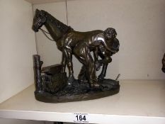 A silvered resin blacksmith with horse resin figure group