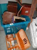 A crate containing a leather camera case and other boxes.
