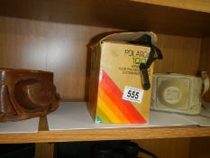 An old Polaroid camera and two other camera's.