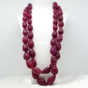 A large and weighty 1144.00ct two strand hand-carved pear-shaped earth-mined ruby bead necklace