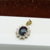 An oval sapphire and diamond halo pendant in 9ct yellow gold