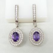 A pair of natural amethyst and double cz halo drop earrings with French clip fittings