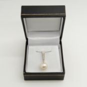 A pearl and diamond bale articulated pendant and chain in 9ct white gold, boxed