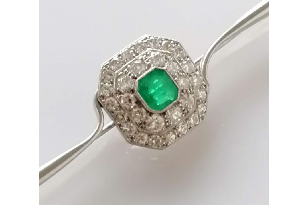 An Art Deco emerald and diamond platinum brooch, the emerald 5mm x 6mm, thirty-one round-cut diamond - Image 1 of 5
