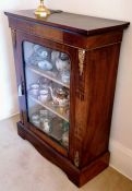 A Victorian walnut display cabinet with glazed door, shelved interior, ormolu mounts and painted flo