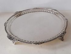 A George V circular silver salver with pierced rim with carved and applied rococo decoration