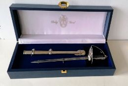 A miniature ceremonial sword/letter opener by Pooley, London, with metal scabbard, in fitted case