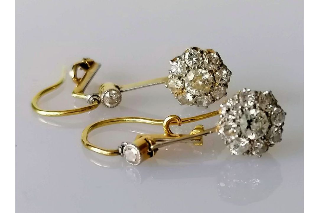 A pair of white and yellow metal diamond earrings, the central round-cut diamond approximately 0.20 - Image 1 of 6